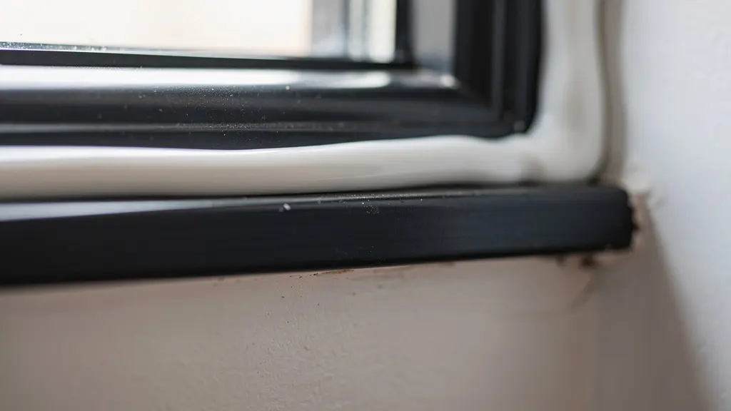 Gros plan sur joint de calfeutrage blanc autour d'un cadre de fenêtre